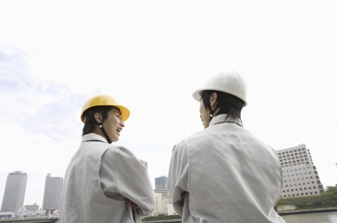 談笑する作業服の男性二人